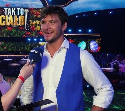 Portret Mikołaja Roznerskiego, polskiego aktora, symbolizujący jego karierę zawodową.
