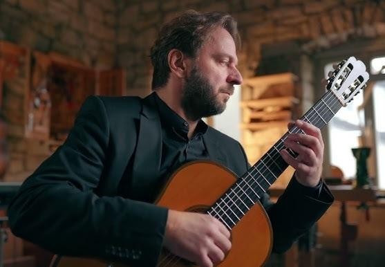Marcin Dylla podczas występu na scenie, ukazujący jego mistrzostwo gry na gitarze.