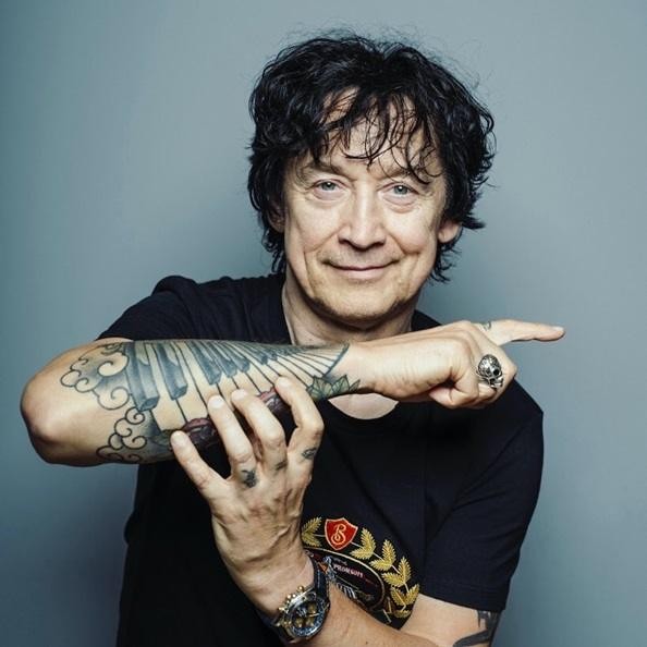 Jan Borysewicz podczas koncertu Lady Pank, grający na gitarze elektrycznej na scenie.