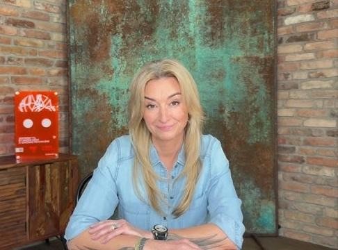 Martyna Wojciechowska w dynamicznej kompozycji, łączącej scenę górską symbolizującą jej wspinaczki (Korona Ziemi) z pustynnym krajobrazem nawiązującym do jej udziału w Rajdzie Dakar, ukazująca jej wszechstronne osiągnięcia jako podróżniczki i sportowca.